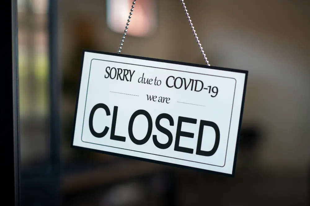 The end of COVID measures featured image. The image shows a 'sorry, we are closed due to covid' sign.