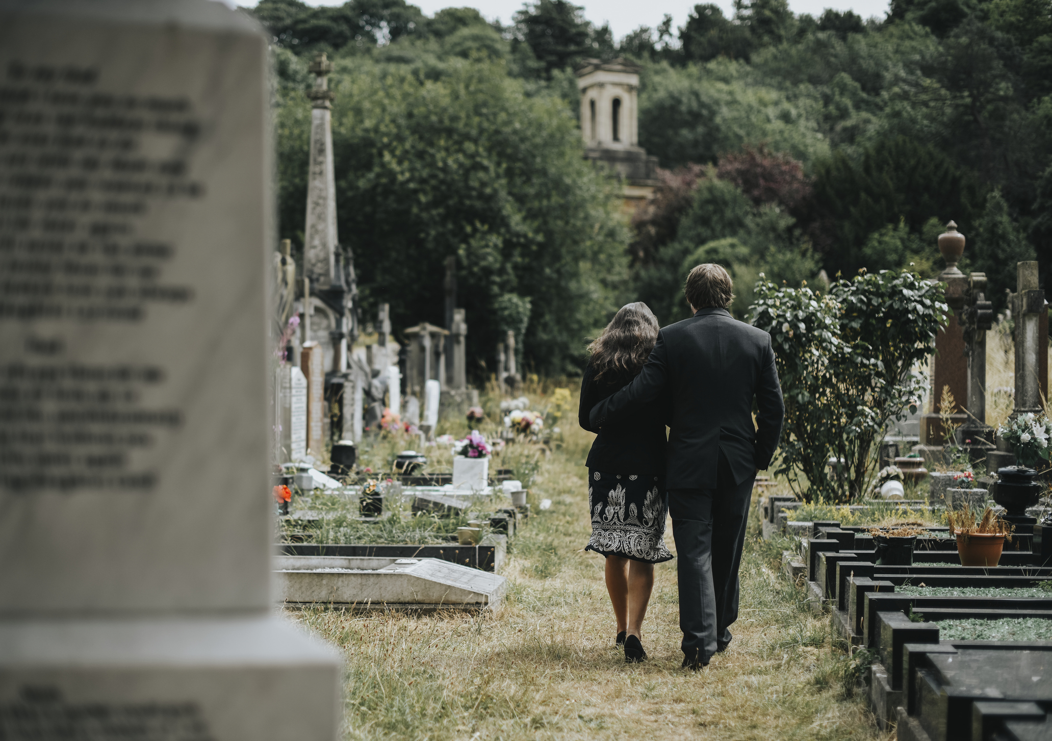 Sad couple walking through a cemetery