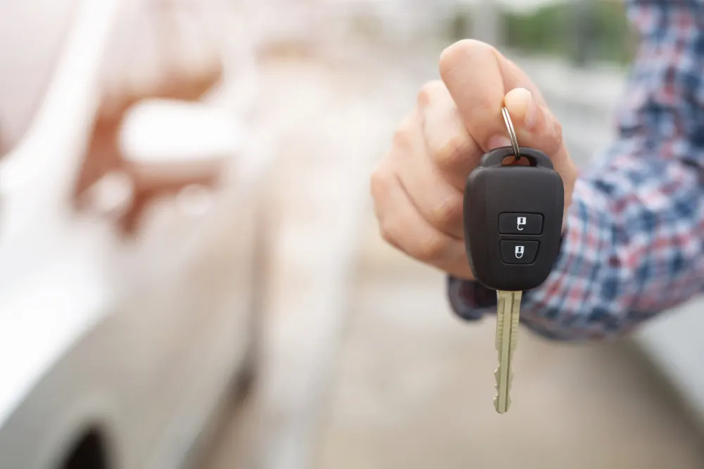 Budget Motorists Feature Image - a hand holding a car key.