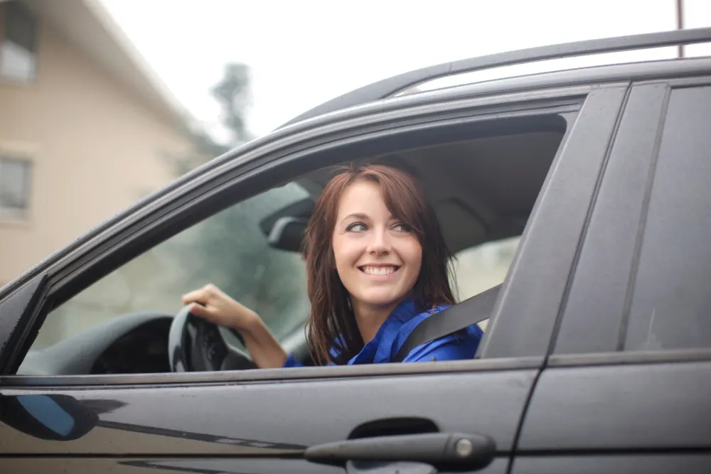 Personal Contract Purchase featured image. Happy woman driving a black car.