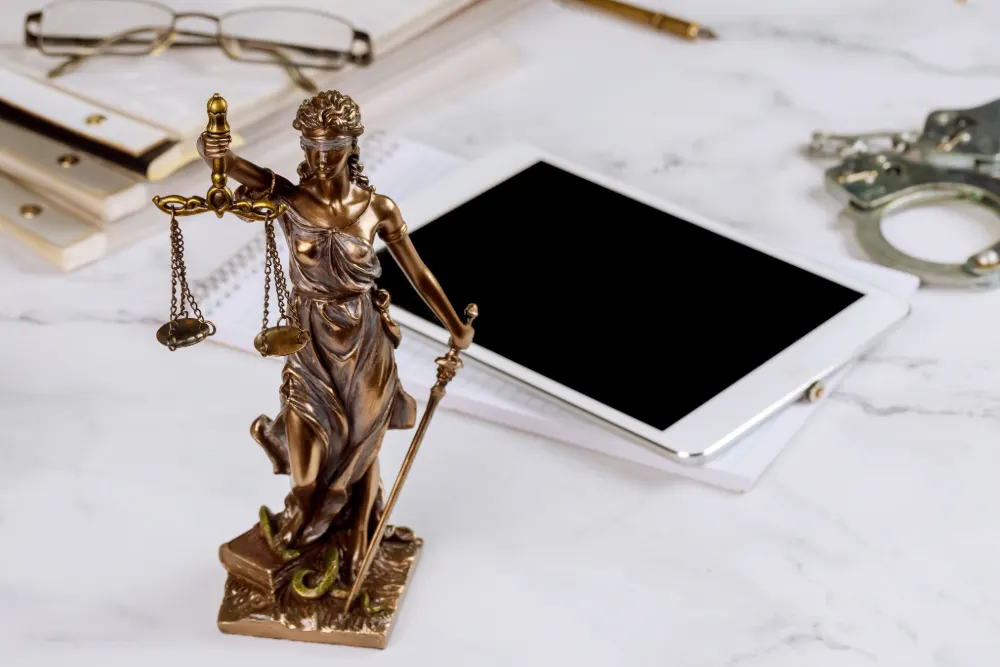 Tech to transform the legal industry featured image. Image shows a justice ornament with scales with a tablet in the background.